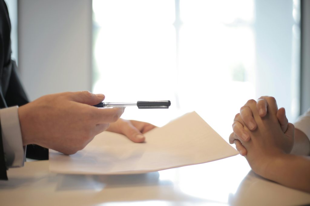 Banks Advisor handing a pen to client to sign their Mortgage Protection policy.